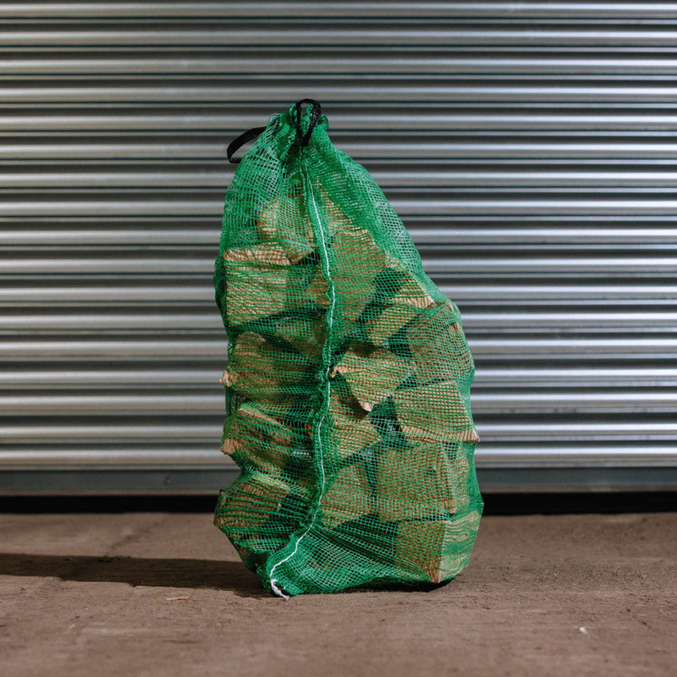 Large net sack of kiln-dried hardwood firewood logs for stoves and fireplaces